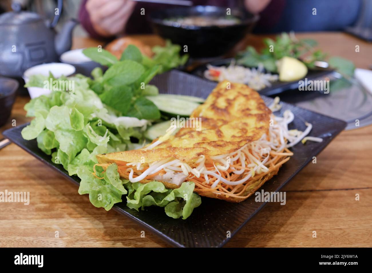 Bánh xèo (crêpe vietnamienne croustillante) avec crevettes, porc, pousses de haricots mung et laitue à Me Pho, Bankstown —- Sydney, Australie Banque D'Images