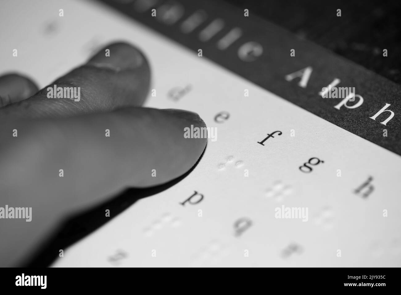 Bouts des doigts touchant le braille sur un morceau de papier en noir et blanc Banque D'Images