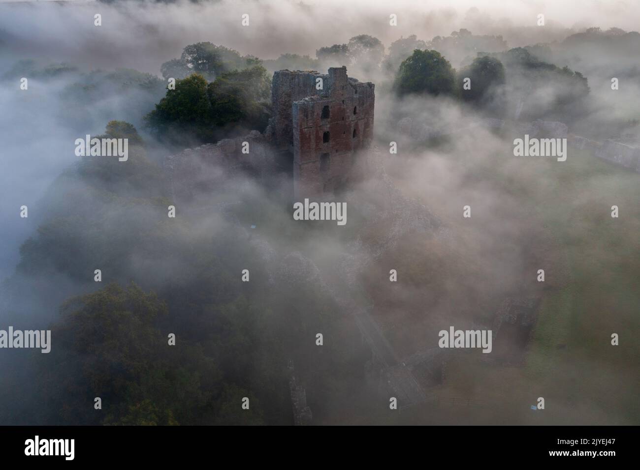 Le château de Norham se lève à travers la brume matinale Banque D'Images