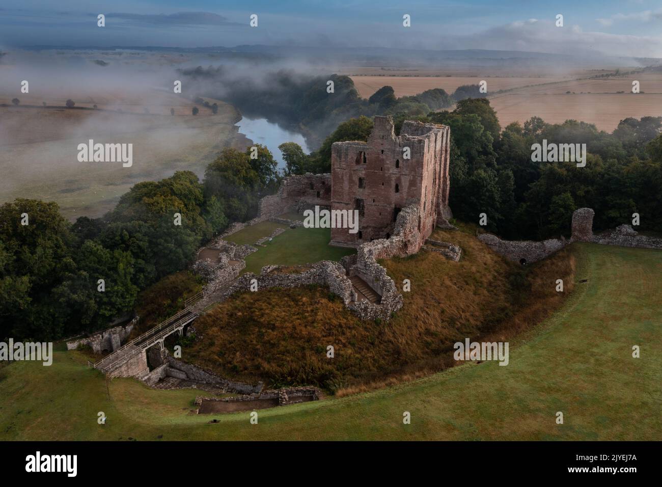 Le château de Norham se lève à travers la brume matinale Banque D'Images