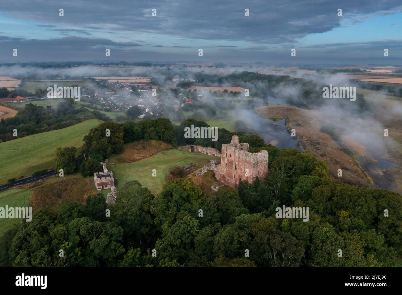 Le château de Norham se lève à travers la brume matinale Banque D'Images