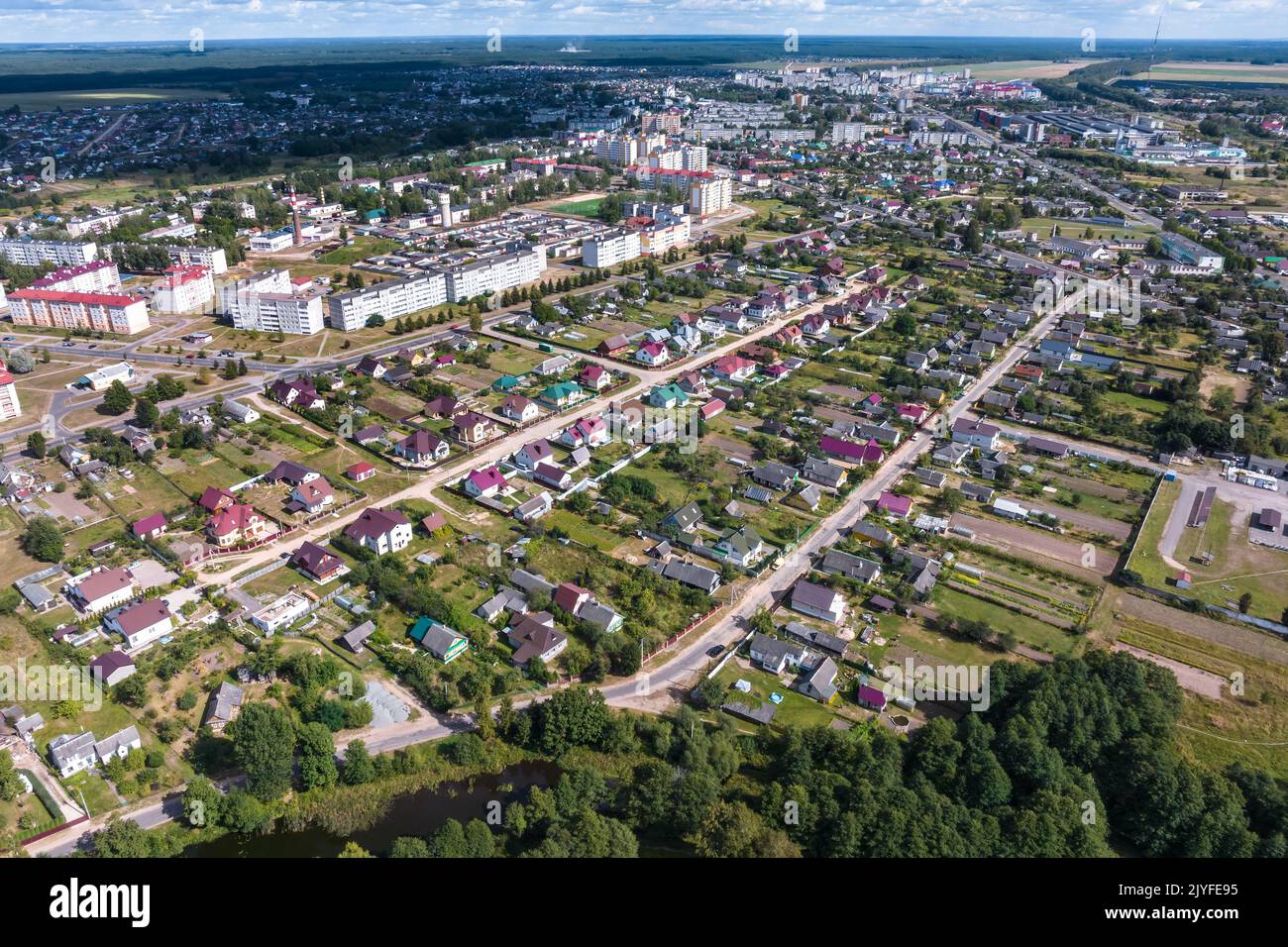 vue panoramique aérienne du village vert avec maisons, granges et route de gravier en forêt Banque D'Images
