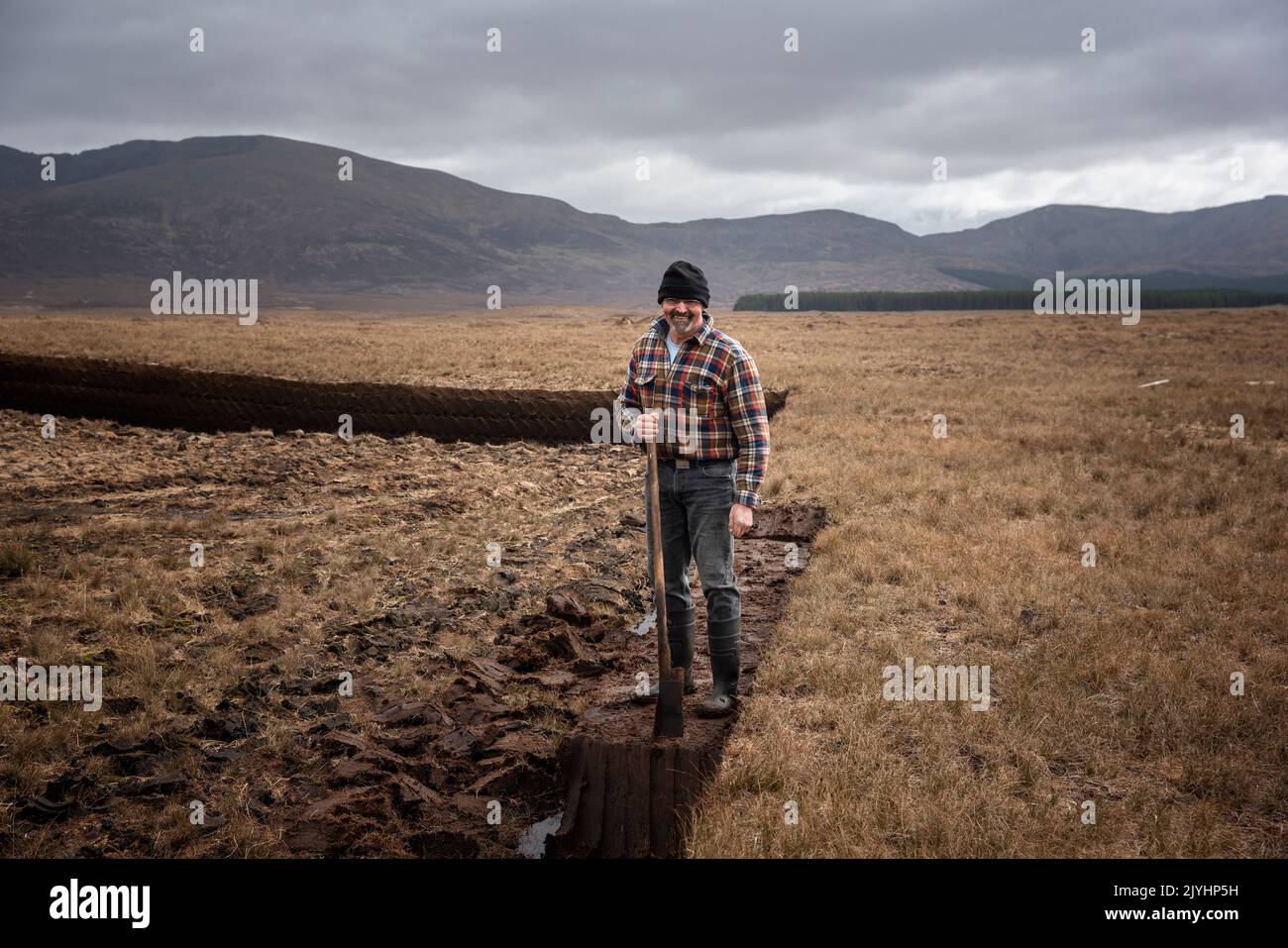 Un coupe-gazon au milieu de la vaste tourbière en bordure du parc national de Ballycroy. Il coupe son gazon à la main, avec un sléan. Banque D'Images