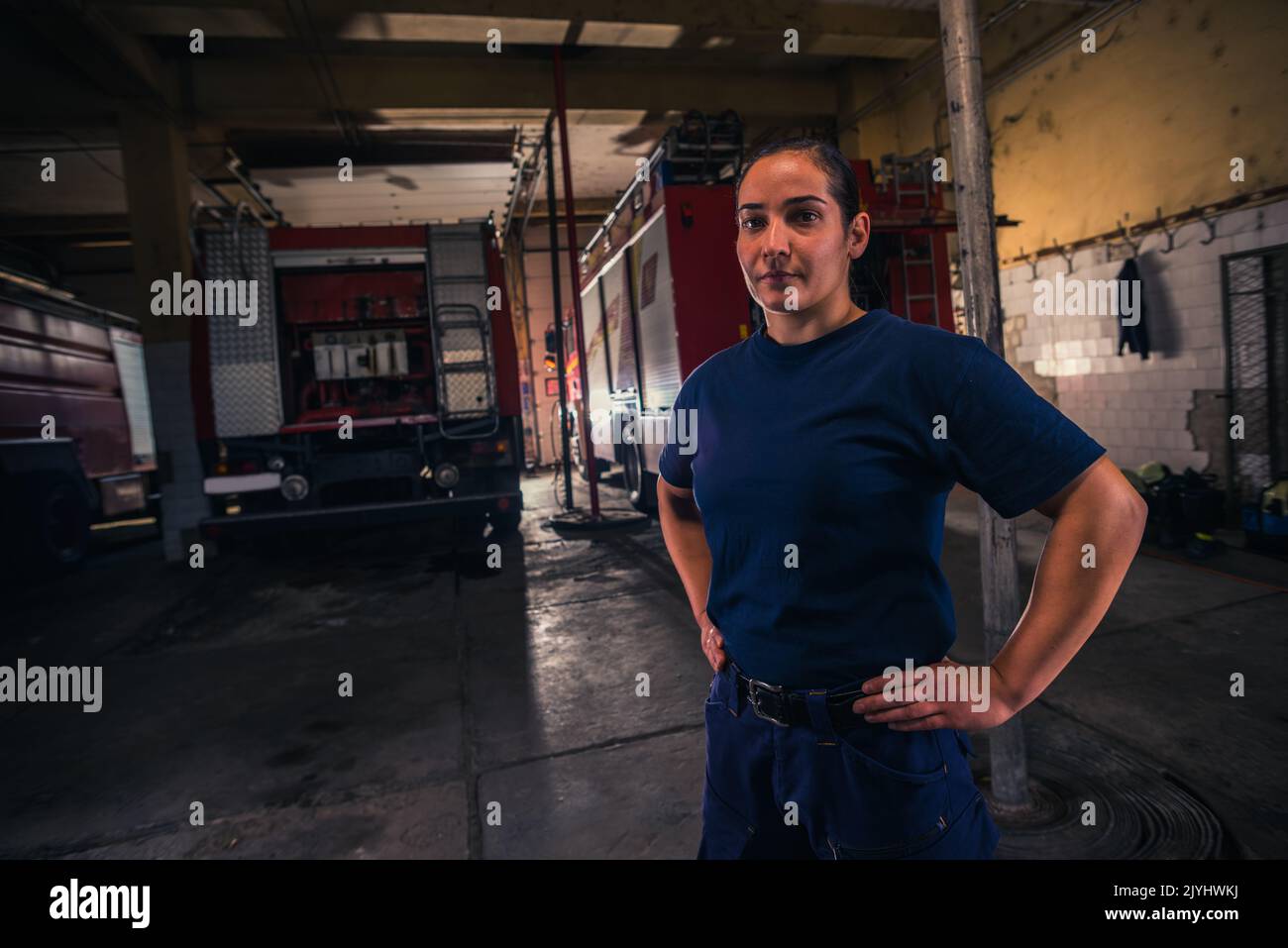 Portrait d'une pompier féminine se tenant contre un camion de pompiers à la station Banque D'Images