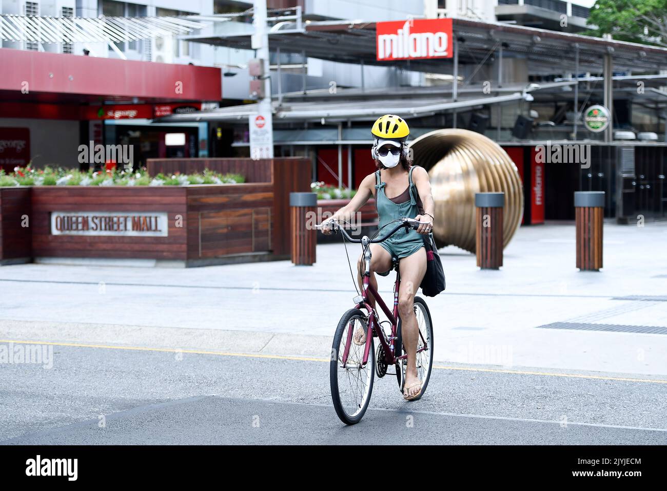 Une femme portant un masque fait une balade à vélo dans la CDB de Brisbane,  lundi, 11 janvier 2021. Le Queensland n'a enregistré aucun nouveau cas de  COVID-19, car le Grand Brisbane