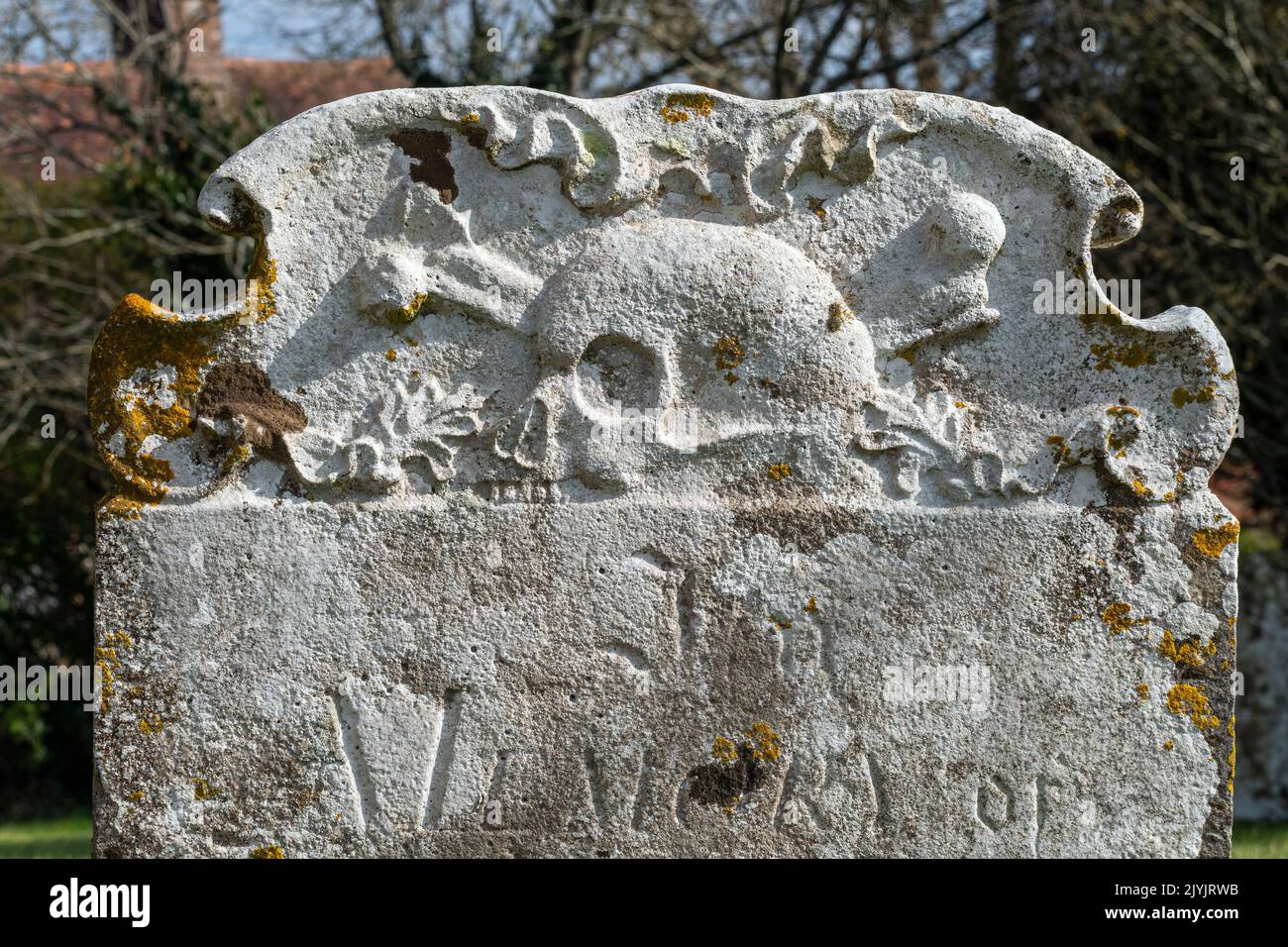 Une pierre tombale avec crâne et crossones dans une cour d'église à Warbleton, dans l'est du Sussex. Banque D'Images