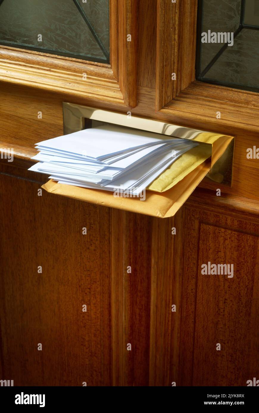 Une boîte aux lettres en laiton dans une porte extérieure farci de mail Banque D'Images