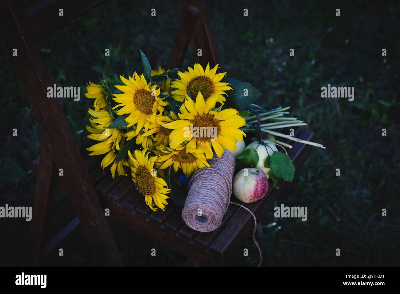 un bouquet de tournesols se trouve sur une chaise vintage au milieu du jardin Banque D'Images
