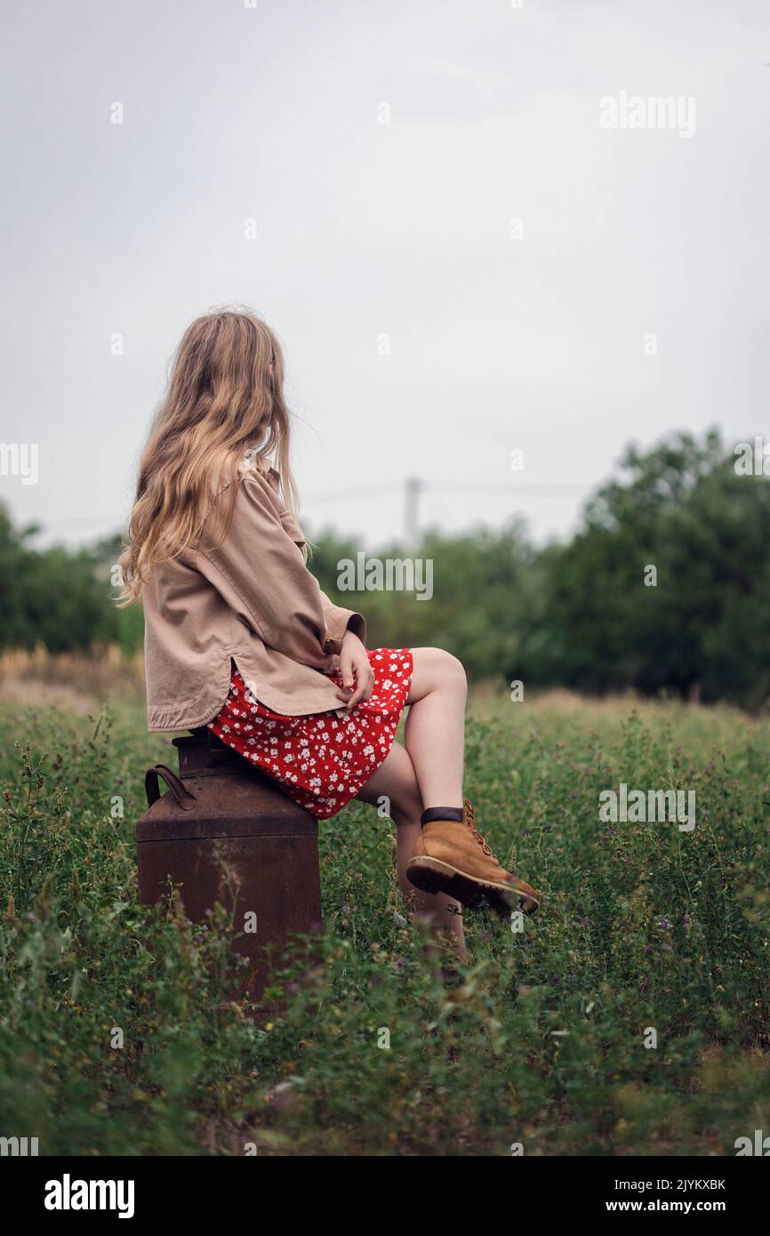 esthétique rurale. fille assise sur une vieille laiteuse Banque D'Images
