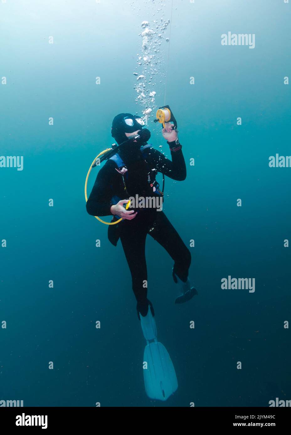 Un plongeur de plongée est sous-marin à un arrêt de sécurité tenant sur la bobine de sa bouée de marqueur de surface Banque D'Images