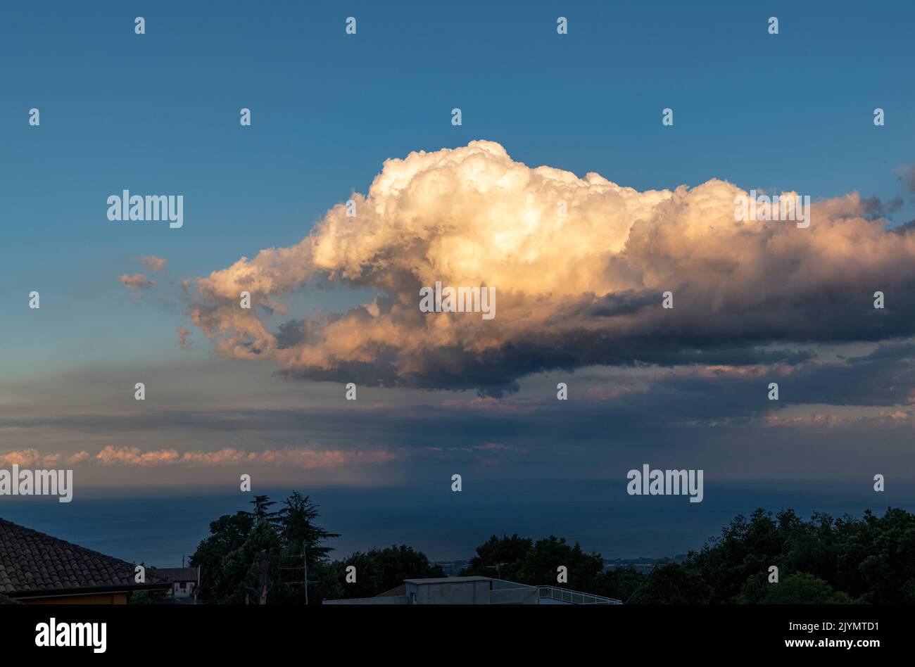 Une étrange formation de nuages en forme d'une main géante, vue du village sicilien de Milo, près de Catane Banque D'Images