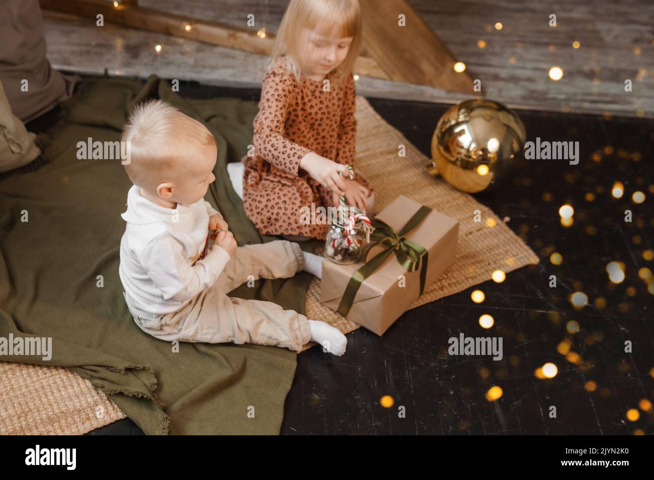 Petit frère et sœur jouent la veille de Noël dans une belle maison décorée  pour les vacances du nouvel an. Les enfants jouent avec un cadeau de Noël  Photo Stock - Alamy