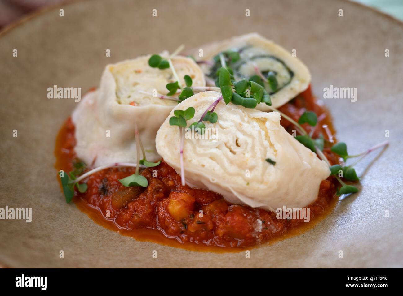 Trois morceaux de 'truklji', boulettes de fromage slovène, plat traditionnel slovène, composé de pâte et de divers types de garniture, servis avec du végétab Banque D'Images