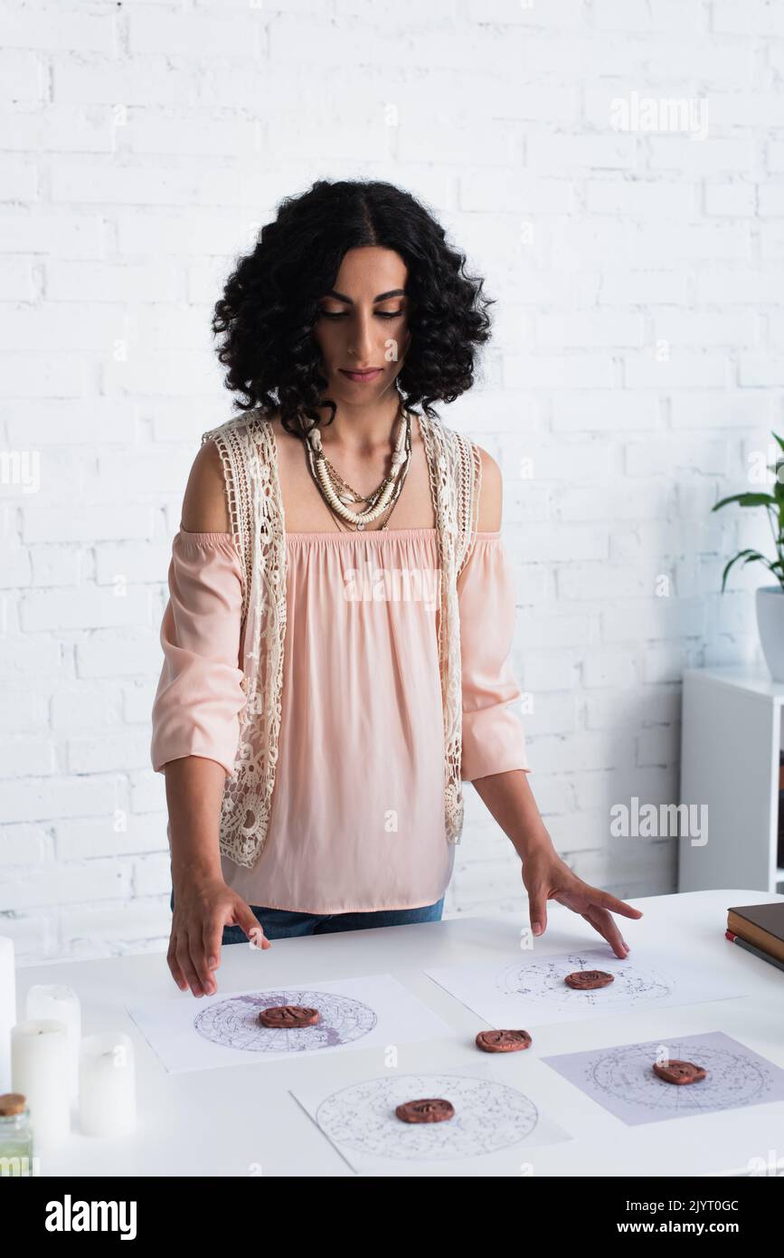 brunette oracle prédit des cartes célestes proches et des runes d'argile Banque D'Images