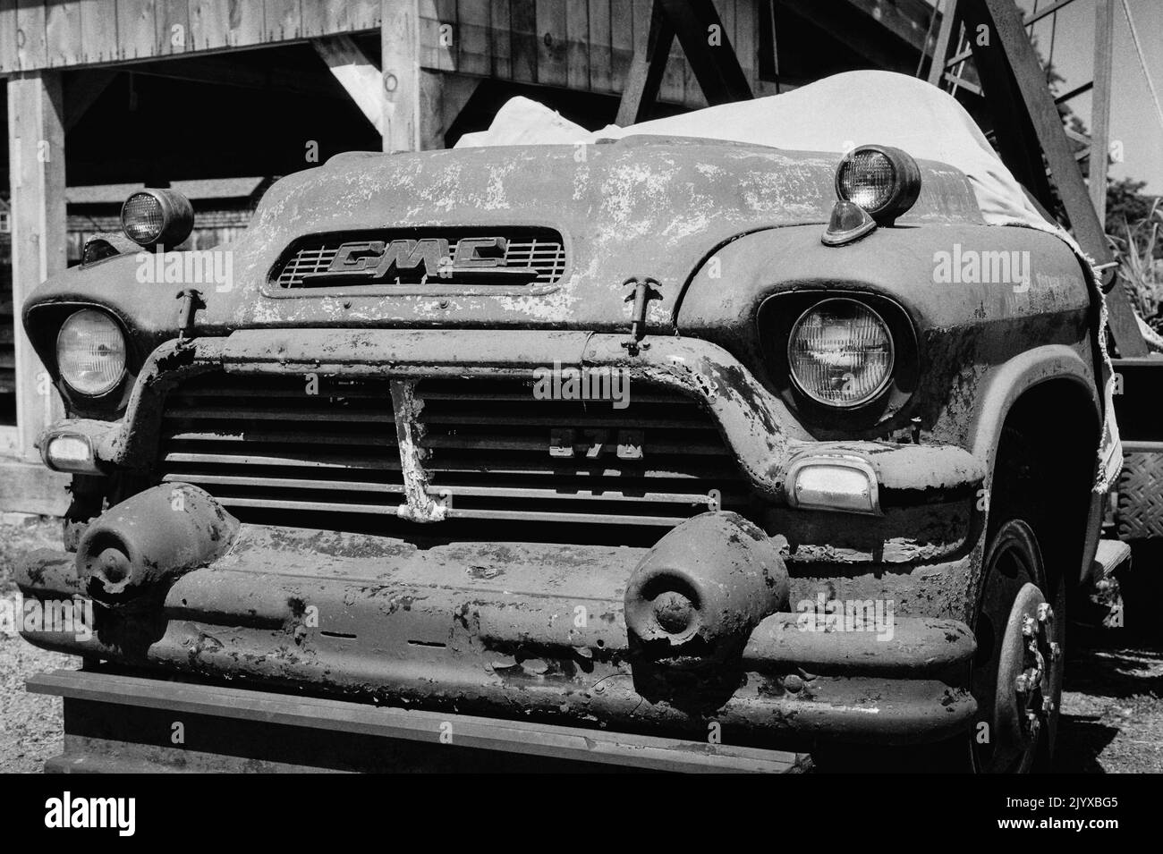 Un camion GMC d'époque s'est converté vers une grue garée à côté de l'eau au musée de la construction navale d'Essex, Essex, Massachusetts. Image capturée en mode analogique Banque D'Images