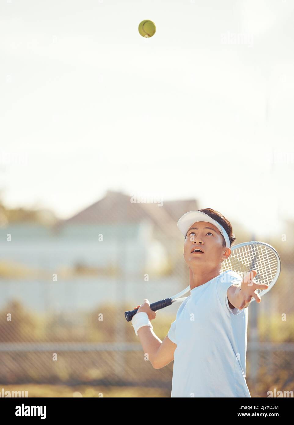 Ballon de tennis, sport de service et de compétition homme d'entraînement ou de jouer un match de jeu avec une raquette sur un court extérieur. Homme sérieux, actif et asiatique Banque D'Images