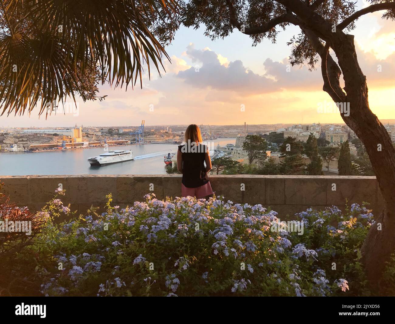 Jeune femme regardant un coucher de soleil magique à Malte. Concept de belle vie, comme dans un film. Concept de blog ou de magazine de voyage, papier peint. Banque D'Images