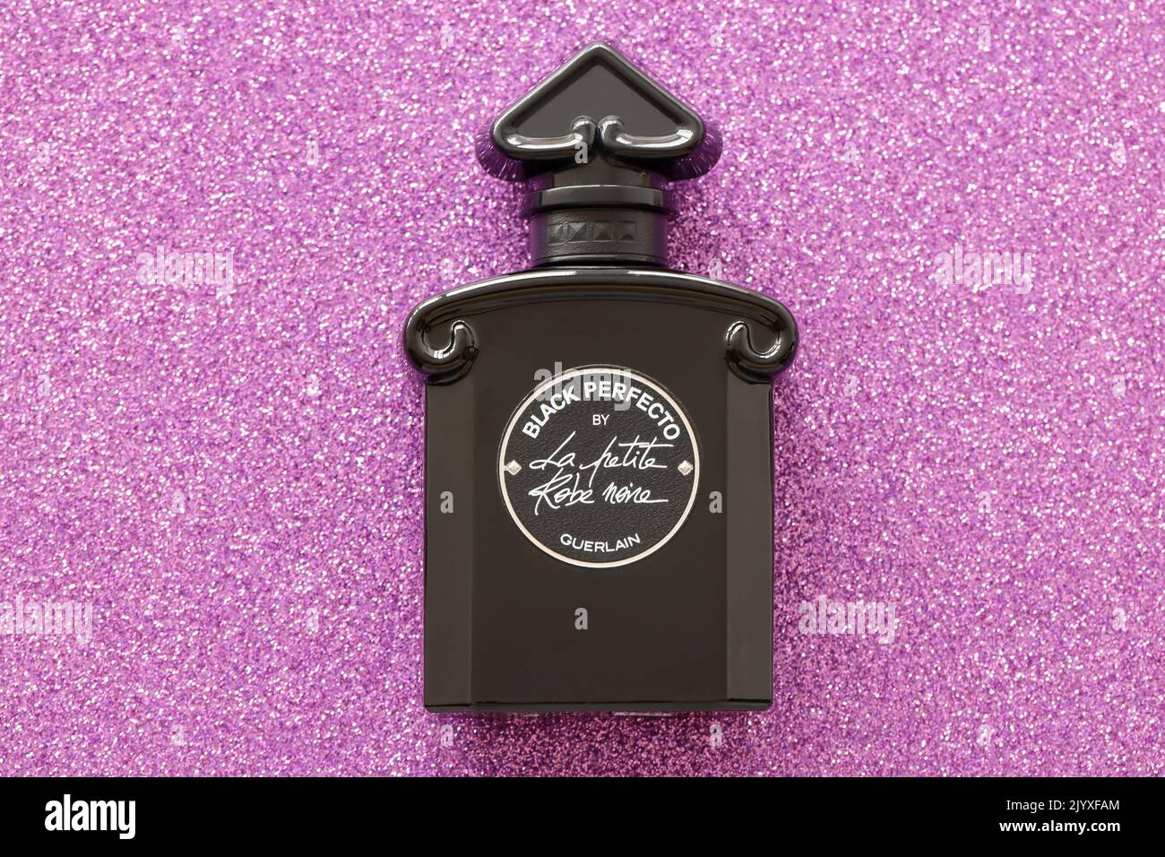 TERNOPIL, UKRAINE - 2 SEPTEMBRE 2022 Perfecto la petite Robe Noire par Guerlain flacon de parfum sur fond brillant en rose et violet co Banque D'Images