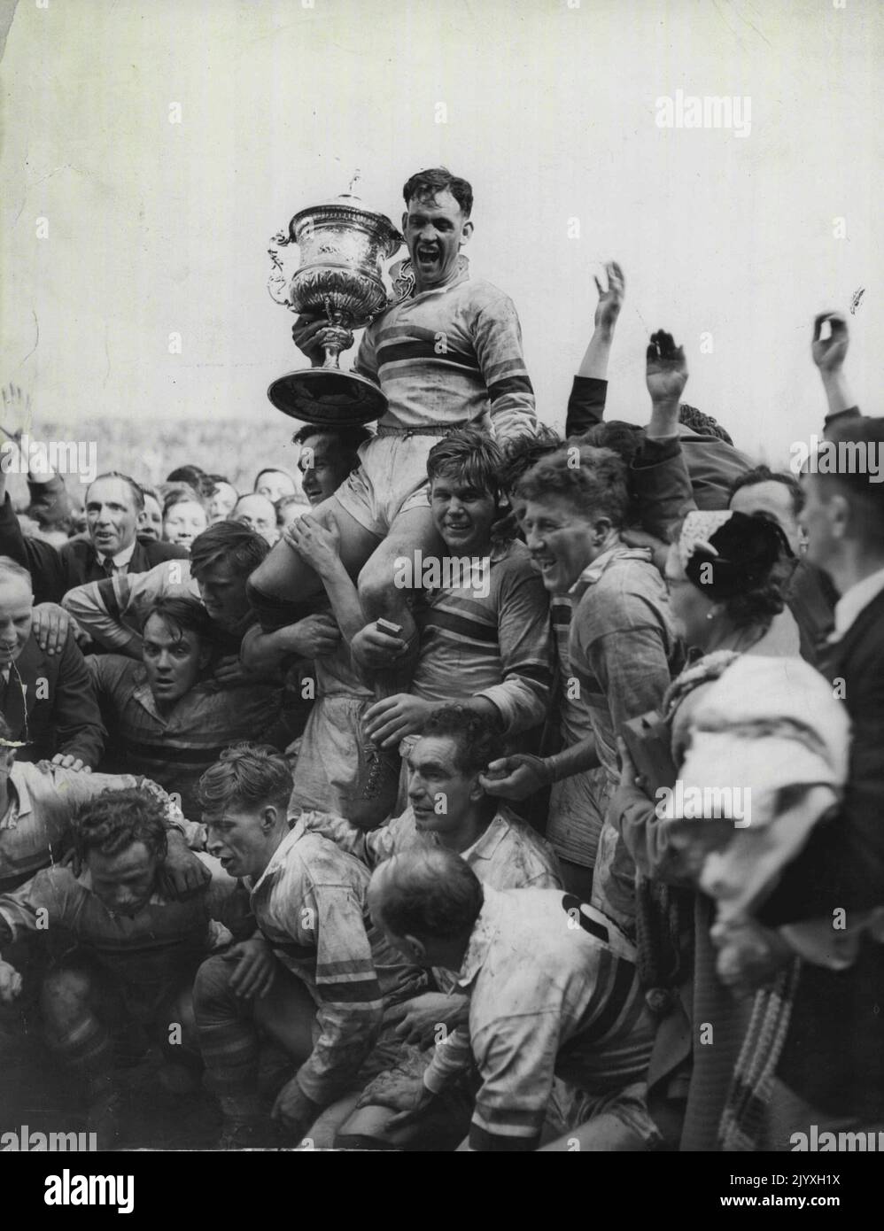Finale de la ligue de rugby (Maine Road). Frodsham, Warrington à fond, et commandant en exercice de Warrington, tiennent avec jubilé la coupe de championnat de la Ligue, soutenue par ses copains d'équipe, qui font pression contre la force de la foule. 8 mai 1954. Banque D'Images