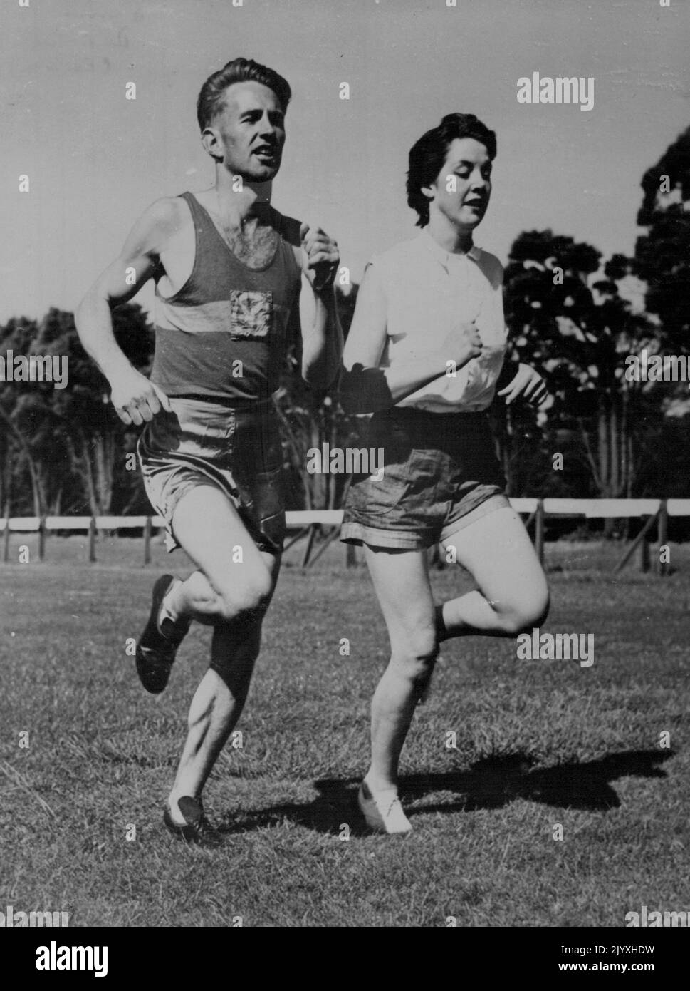 Épouse est partenaire d'entraînement olympique. Accompagné de sa belle femme de 18 ans, Beverley, Dave Stephens se détend avec une séance de formation. Dave est reconnu comme l'un des plus grands espoirs de l'Australie pour une médaille d'or lors des prochains Jeux olympiques de l'année prochaine. Étudiant à Melbourne, il s'est déjà établi comme l'un des meilleurs coureurs de fond au monde. Sa femme a pris l'athlétisme pour accompagner son mari pendant l'entraînement. 1 juin 1955. Banque D'Images