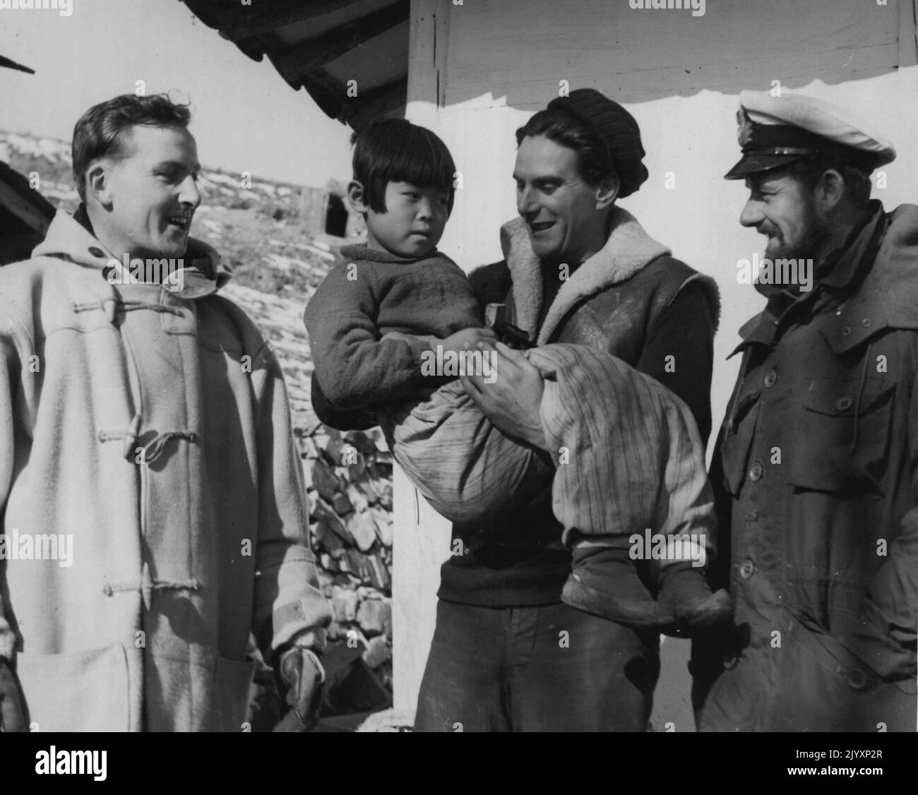 Chirurgien Lieut. M. Lydon, de la frégate australienne Condamine dont le domicile est à Galway, Eire, avec un des patients dans l'orphelinat, qui est détenu par l'Able Seaman G.R. Garner, Hatfield Herts, tandis que barbu commandé Gunner M. P. Stubbs de Rustington, Sussex, regarde sur. 02 janvier 1953. Banque D'Images