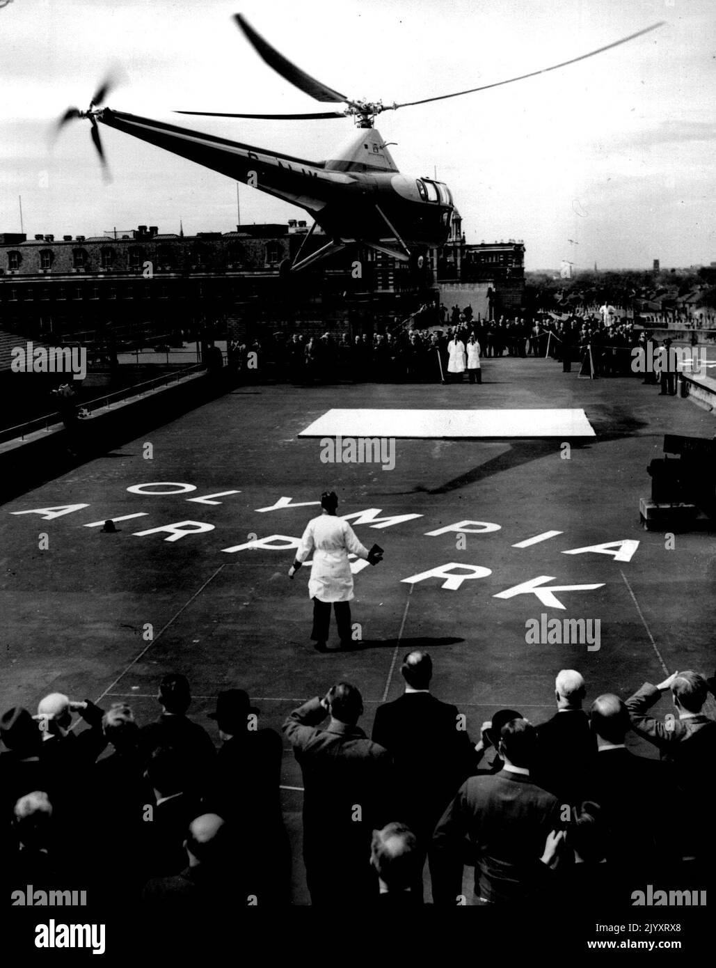 Liaisons par hélicoptère vers Londres et Paris -- la foule sur le toit des garages Metropolis, regardez l'hélicoptère tandis qu'il part de Londres à Paris. Un hélicoptère Westland-Sikorsky a décollé du toit des garages Metropolis, à côté d'Olympia (Londres) jusqu'au jour le jour (mer) pour un vol vers Paris. Ce nouveau service est conçu pour soulager les passagers aériens des problèmes de transport qui se produisent sur les vols normaux. Les passagers voyageant par hélicoptère pourront monter presque jusqu'à la bande d'air du toit, monter à bord de l'avion, et deux heures et demie plus tard, se retrouver dans le Banque D'Images Liaisons par hélicoptère vers Londres et Paris -- la foule sur le toit des garages Metropolis, regardez l'hélicoptère tandis qu'il part de Londres à Paris. Un hélicoptère Westland-Sikorsky a décollé du toit des garages Metropolis, à côté d'Olympia (Londres) jusqu'au jour le jour (mer) pour un vol vers Paris. Ce nouveau service est conçu pour soulager les passagers aériens des problèmes de transport qui se produisent sur les vols normaux. Les passagers voyageant par hélicoptère pourront monter presque jusqu'à la bande d'air du toit, monter à bord de l'avion, et deux heures et demie plus tard, se retrouver dans le Banque D'Images