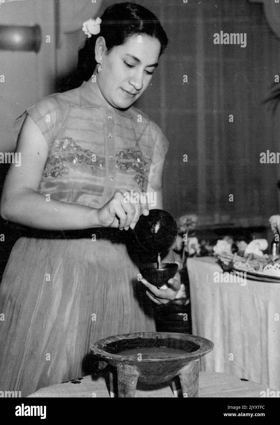 La reine Salote des Tonga a donné une fête d'adieu à Londres ce soir. Cette photo montre ici la fille en droit, la princesse Mata Aho, préparer la boisson nationale des Tonga Karva qui est ivre de noix de coco. 6 juillet 1953. (Photo par photo de contrat de courrier quotidien) Banque D'Images