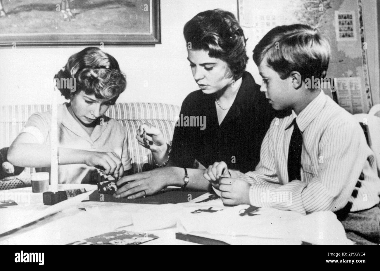 Les enfants royaux suédois préparent leurs cadeaux de Noël. Occupé comme toute autre famille - préparer leurs cadeaux de Noël sont les enfants royaux de Suède - le prince héritier Carl Gustaf (à droite) regardant sa sœur la princesse Christina (à gauche) à 12 ans, et la princesse Hargaretha, à 21 ans, dans le château royal de Stockholm. 22 décembre 1955. (Photo par AP Wirephoto) Banque D'Images