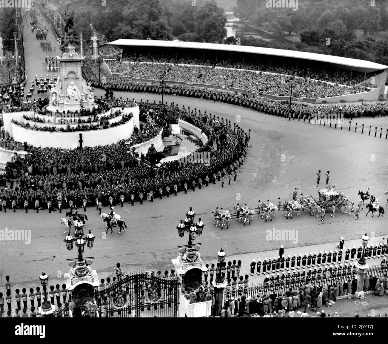 Photo du dossier datée du 2/6/193 de la vue du toit du palais de Buckingham montrant l'entraîneur d'État transportant la reine Elizabeth II et le duc d'Édimbourg à l'abbaye de Westminster pour le couronnement de la reine. Le couronnement de la Reine - riche en importance religieuse, a été un coup de pouce au moral d'une nation affamée d'infanterie par la guerre - et pendant un jour, les partis de rue ont banni les épreuves du rationnement et des pénuries et même les conditions météorologiques atroces et non saisonnières n'ont pas freiné l'enthousiasme. Date de publication : jeudi 8 septembre 2022. Banque D'Images