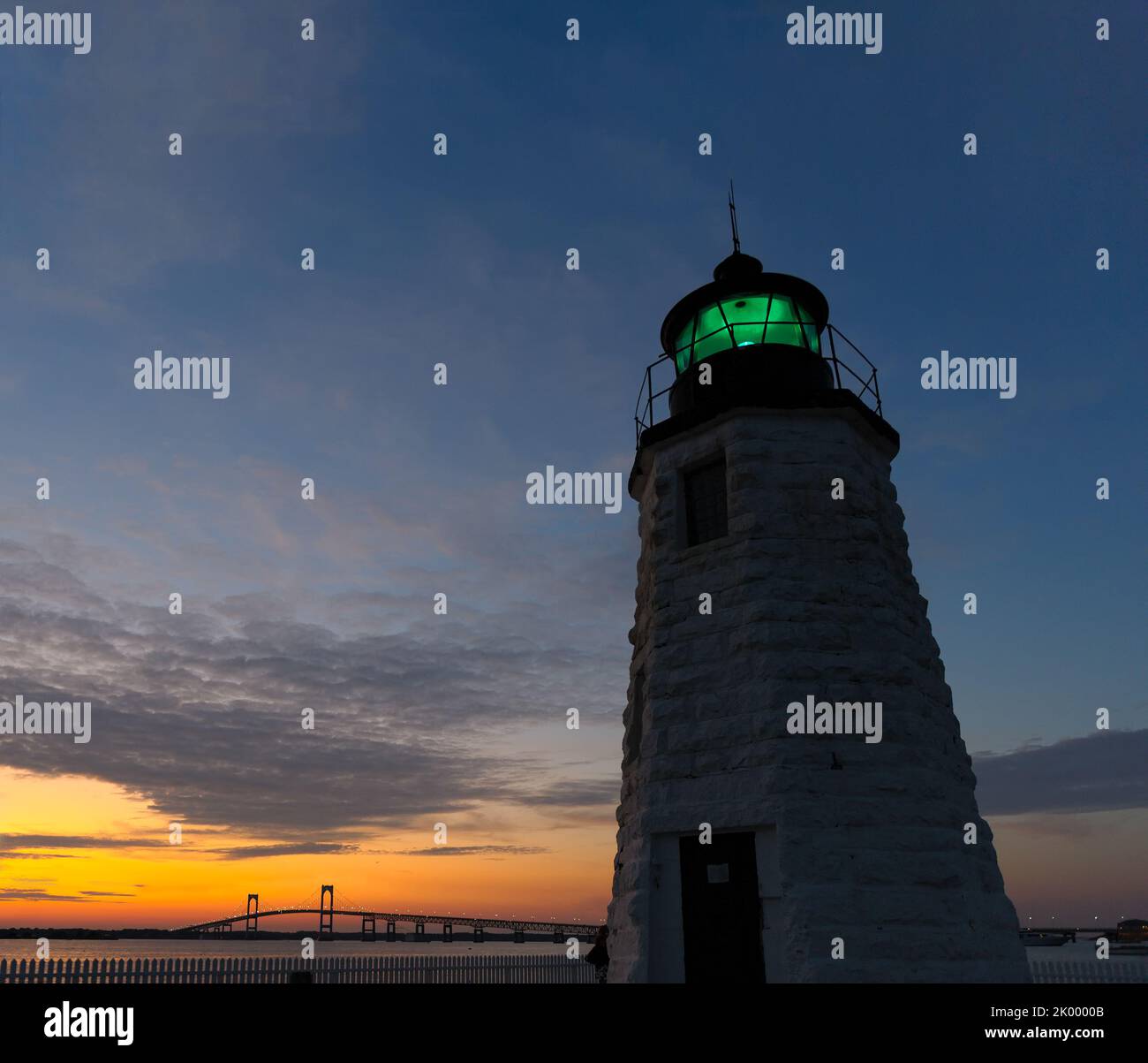 Phare de Newport Harbor alias Goat Island Light House la nuit avec feu vert allumé et le pont Claiborne Pell Newport, Newport, Rhode Island. Banque D'Images