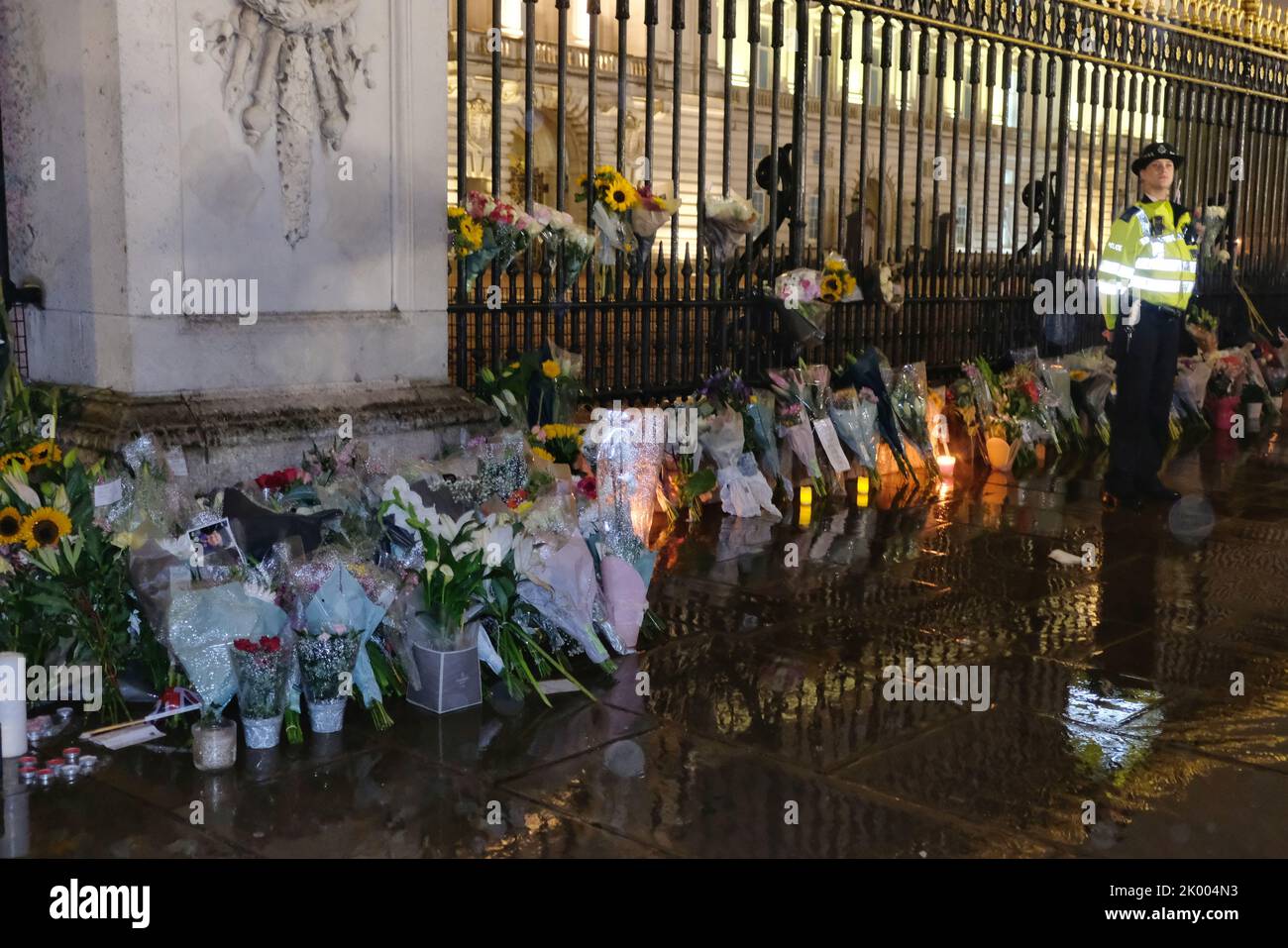 Londres, Royaume-Uni, 8th septembre 2022. Une rangée de fleurs se trouve près des portes de Buckingham Palace, après que les membres du public aient payé leurs respects devant la résidence de sa Majesté la Reine à Londres. Des groupes se sont rassemblés jusque tard dans la nuit après que son décès a été annoncé en début de soirée. Le pays va maintenant entrer dix jours de deuil alors que le règne de 70 ans du monarque arrive à sa fin. Crédit: Onzième heure de photographie/Alamy Live News Banque D'Images