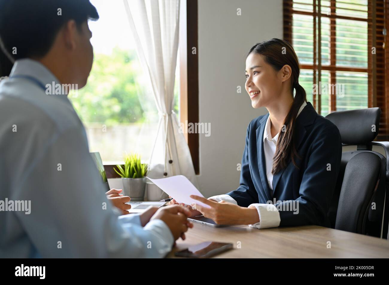 Une femme gestionnaire asiatique professionnelle ou un recruteur des ressources humaines interviewant deux candidats au bureau. Entretien d'emploi et concept de recrutement Banque D'Images