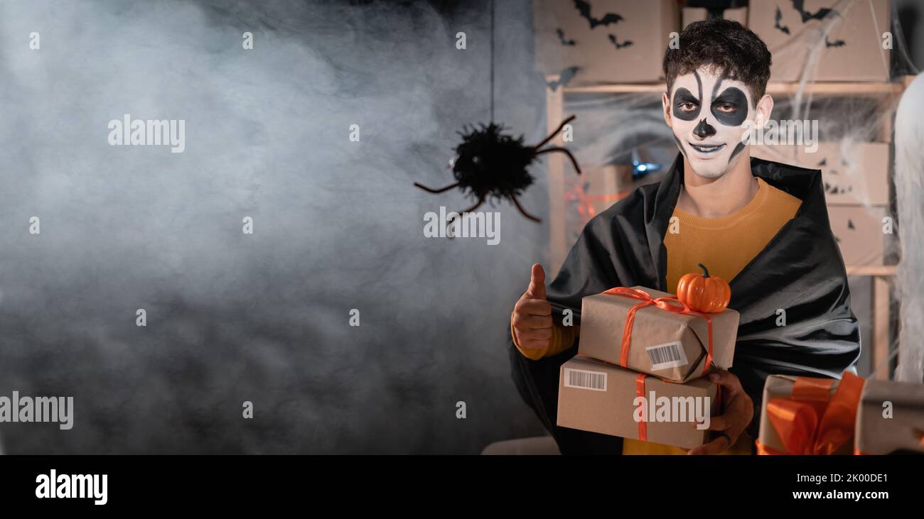 Chute propriétaire d'affaires d'expédition parlant portant le crâne d'argile blanc, bureau à la maison de maquillage professionnel préparant la marchandise pour l'expédition. Soldes d'Halloween Banque D'Images