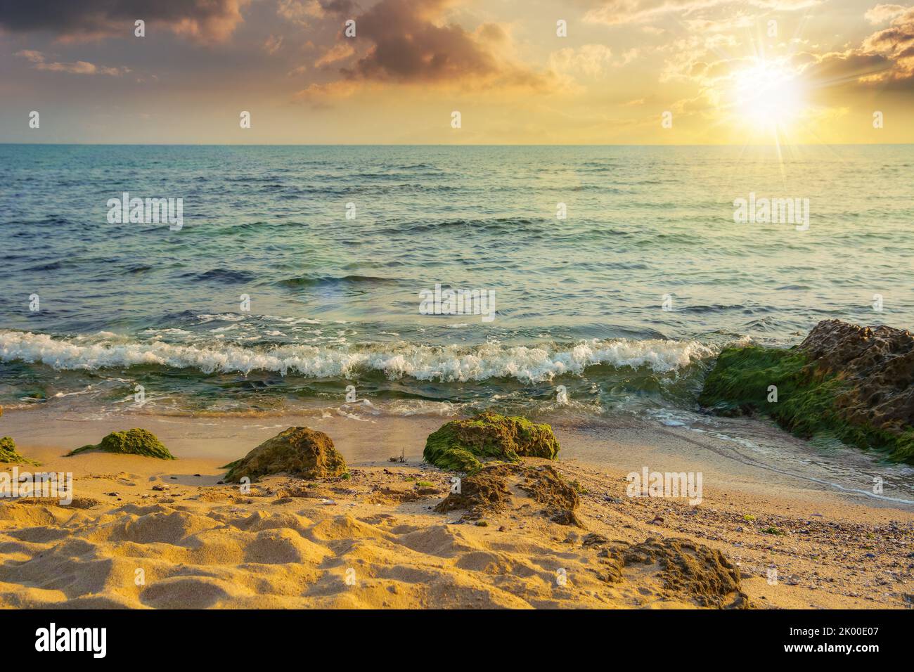 coucher de soleil sur la mer. vagues calmes, lavage de la plage de sable. eau transparente et ciel bleu vif à la lumière du soir Banque D'Images