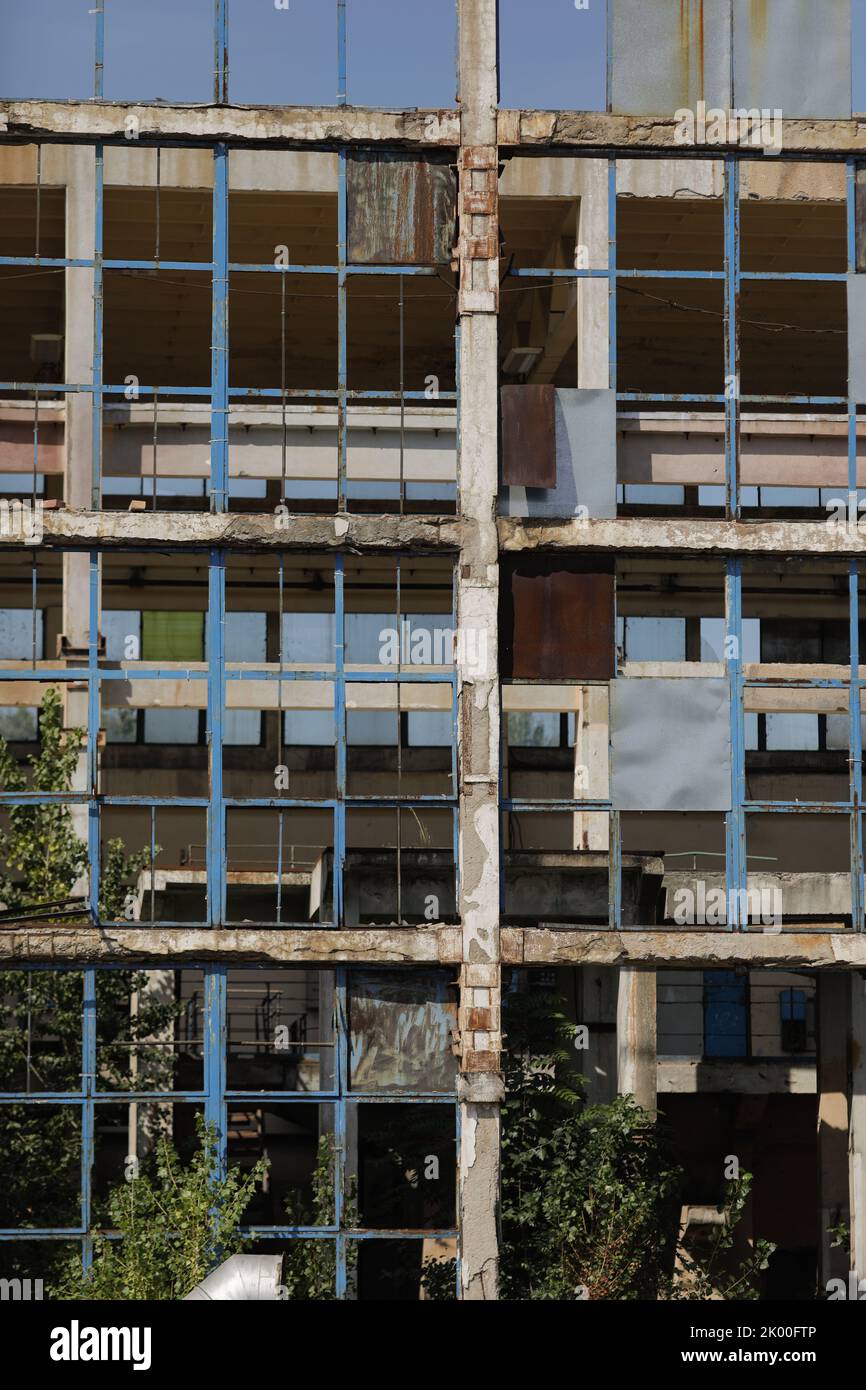 Murs et fenêtres cassés dans un bâtiment industriel abandonné. Banque D'Images
