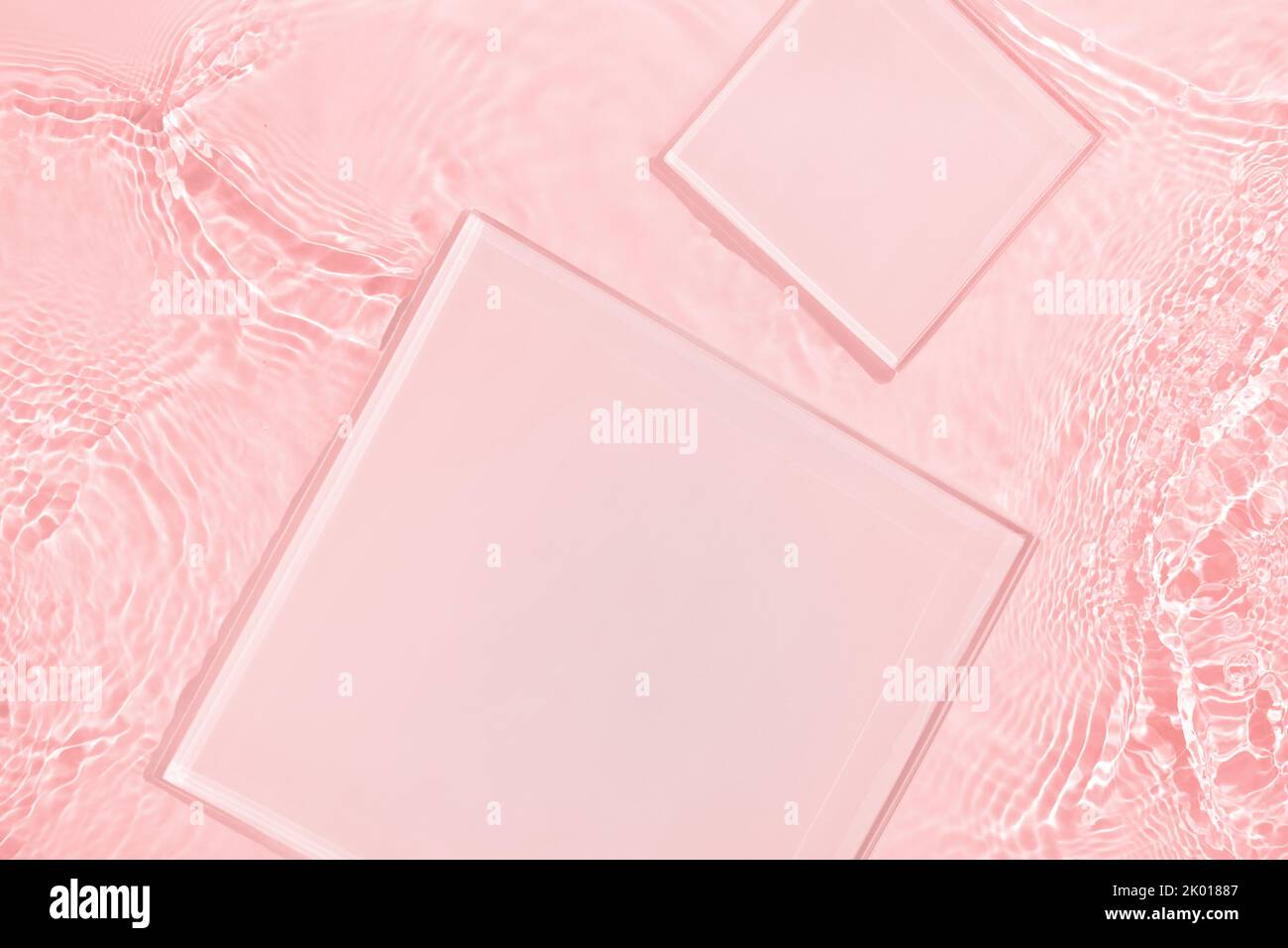 Deux podiums carrés vides sur fond d'eau rose transparent Banque D'Images