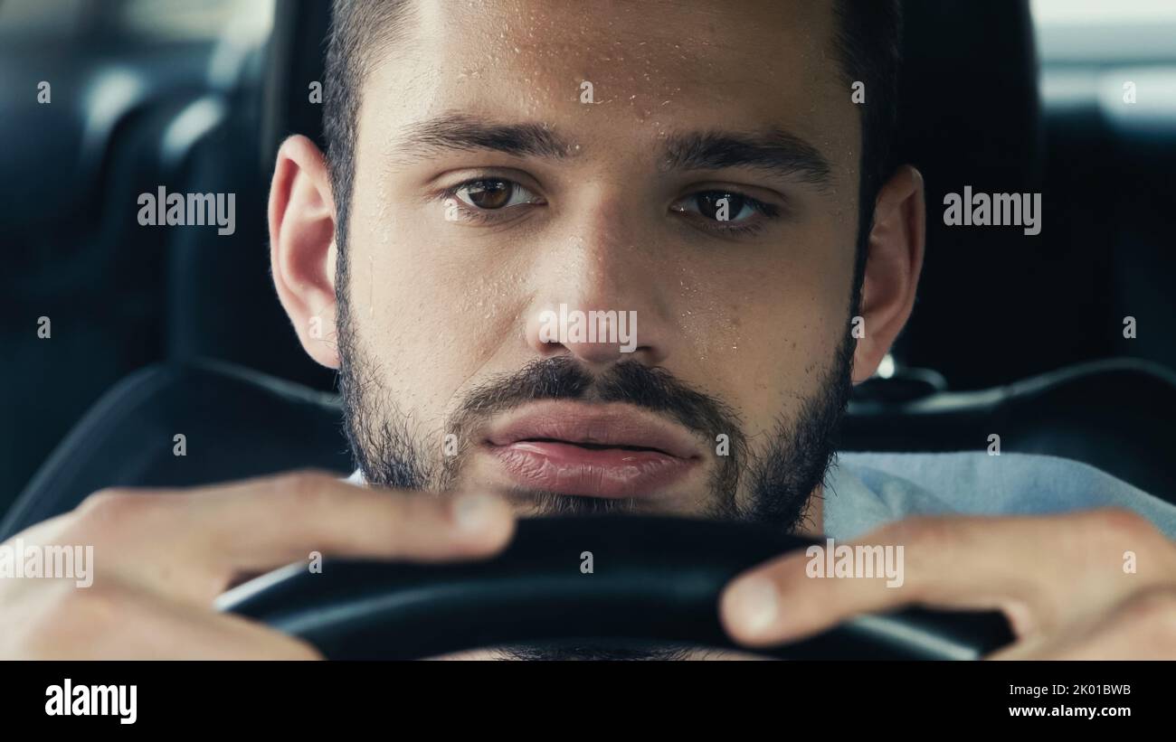 homme fatigué avec la voiture de conduite de front sueur tout en souffrant de la chaleur, image de stock Banque D'Images