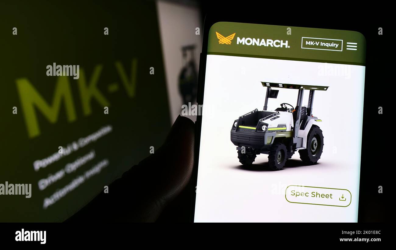 Personne tenant un téléphone portable avec la page web et le logo de la société Zimeno Inc. (Monarch Tractor) à l'écran avec moniteur. Concentrez-vous sur le centre de l'écran du téléphone. Banque D'Images