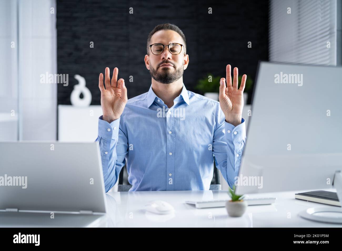 Gestion du stress humain. Méditer près de l'ordinateur dans le bureau Banque D'Images