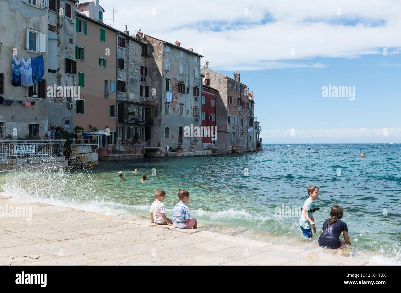 Enfants jouant dans l'eau sur le remblai de la ville historique de Rovinj, Croatie, Europe Banque D'Images