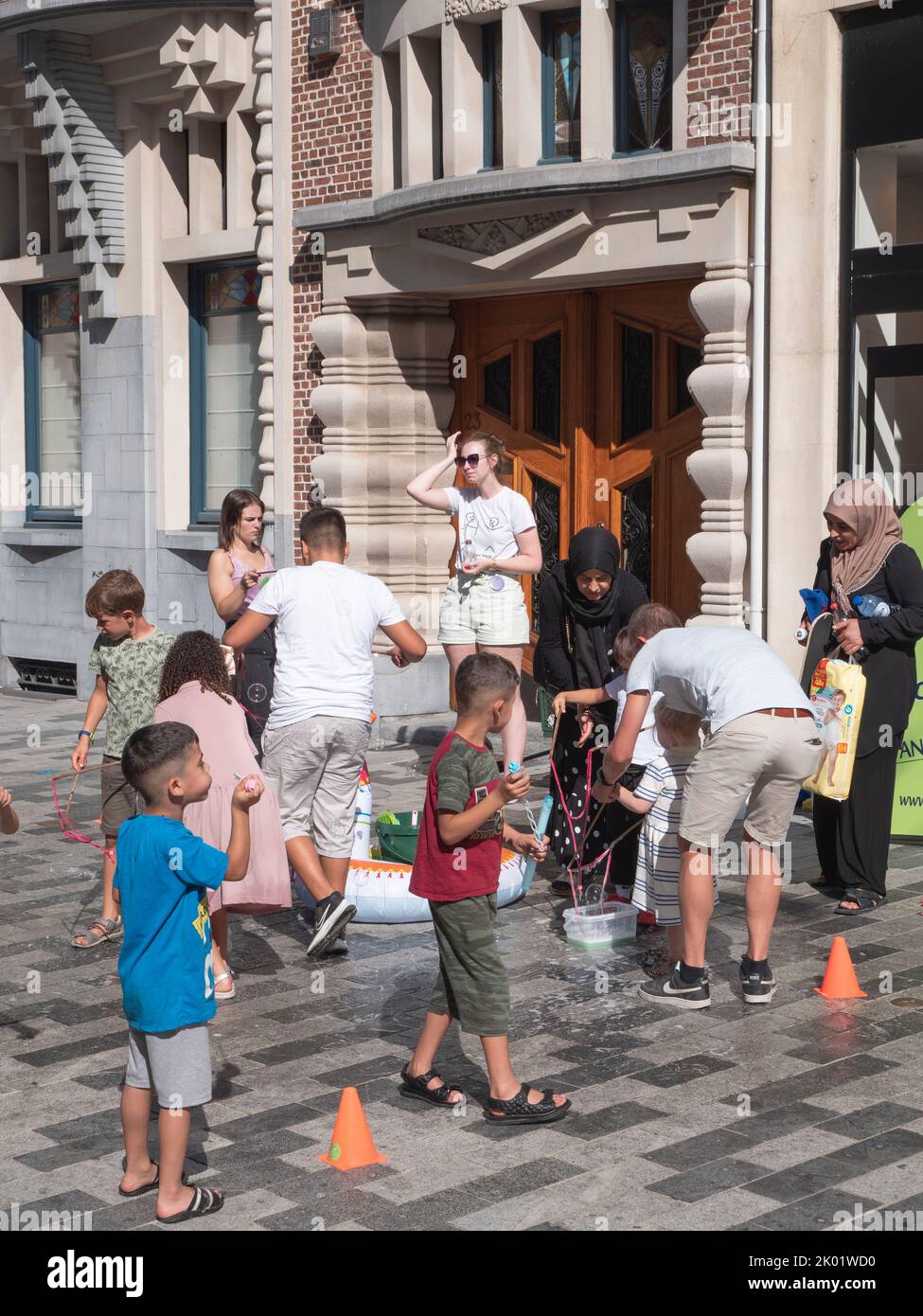 Sint Niklaas, Belgique, 4 septembre 2022, les enfants jouent avec leurs parents dans la rue avec de l'eau et des bulles de savon Banque D'Images
