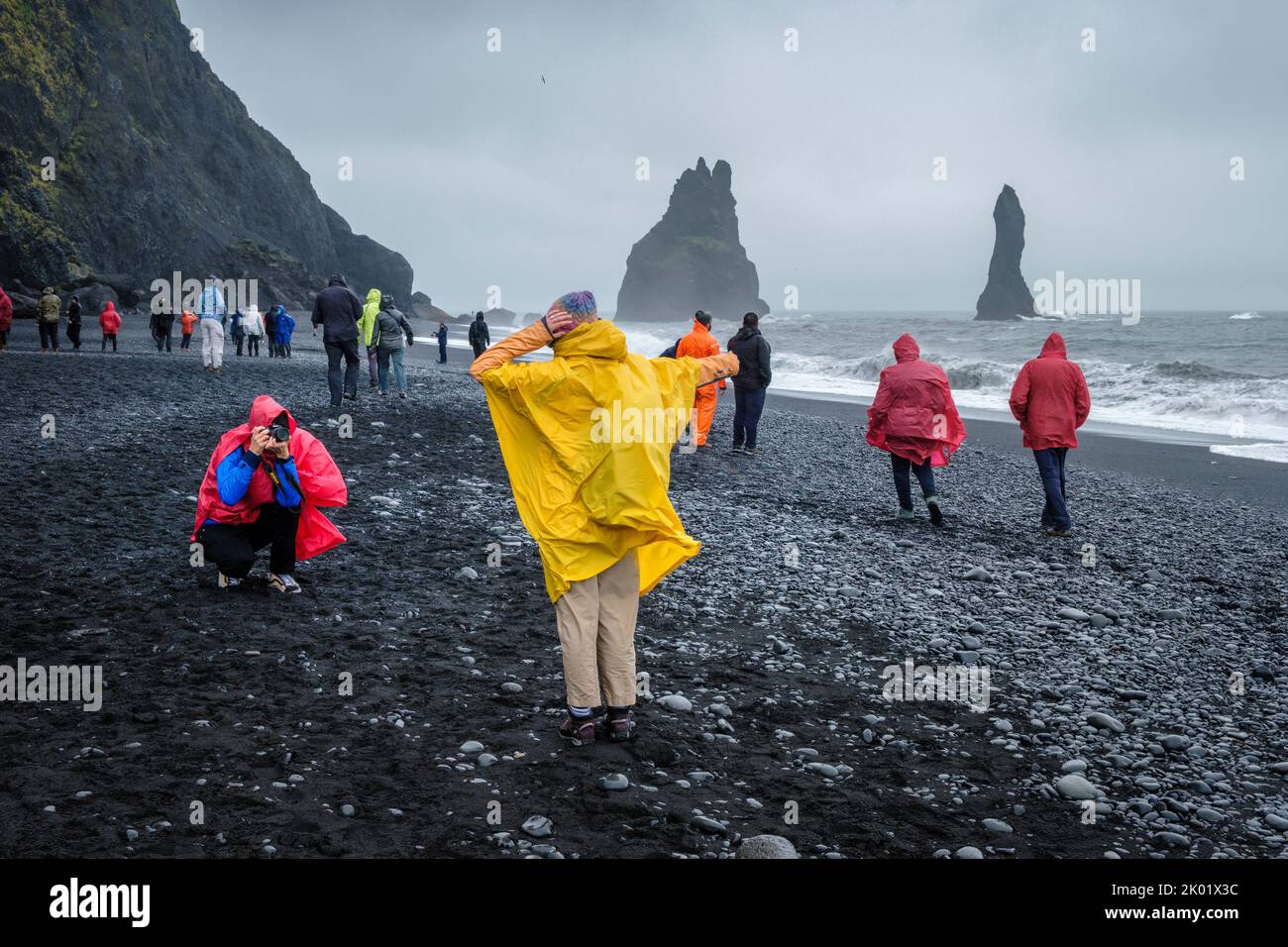 Touristes prenant des photos sur la plage de sable noir (Reynisfjara), Vik, Islande Banque D'Images Touristes prenant des photos sur la plage de sable noir (Reynisfjara), Vik, Islande Banque D'Images