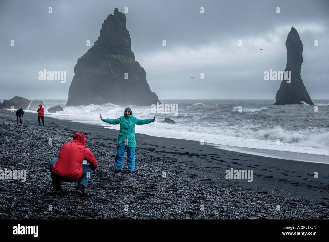 Touristes prenant des photos sur la plage de sable noir (Reynisfjara), Vik, Islande Banque D'Images Touristes prenant des photos sur la plage de sable noir (Reynisfjara), Vik, Islande Banque D'Images