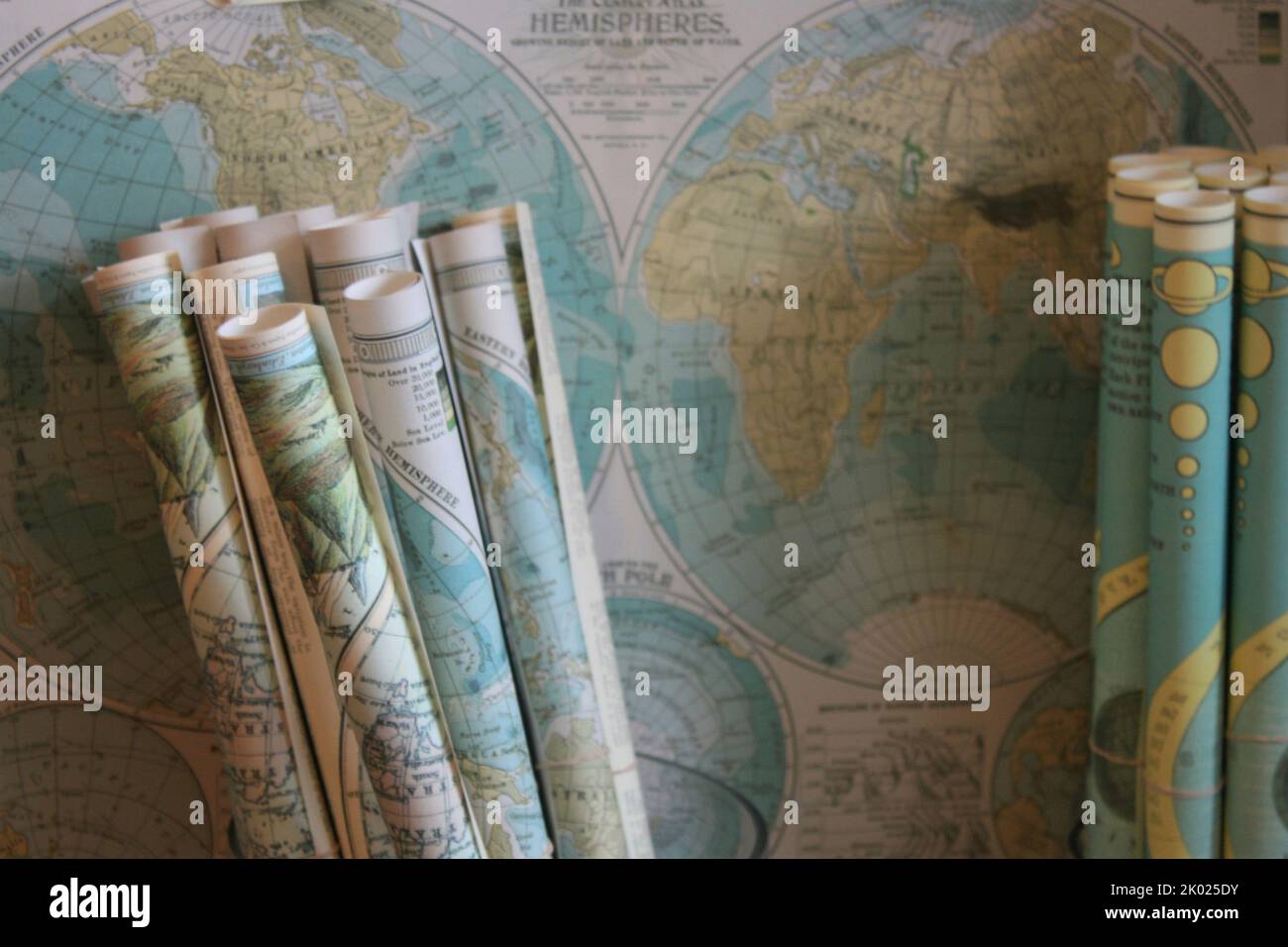 Cartes roulées sur une carte du monde sur le mur Banque D'Images