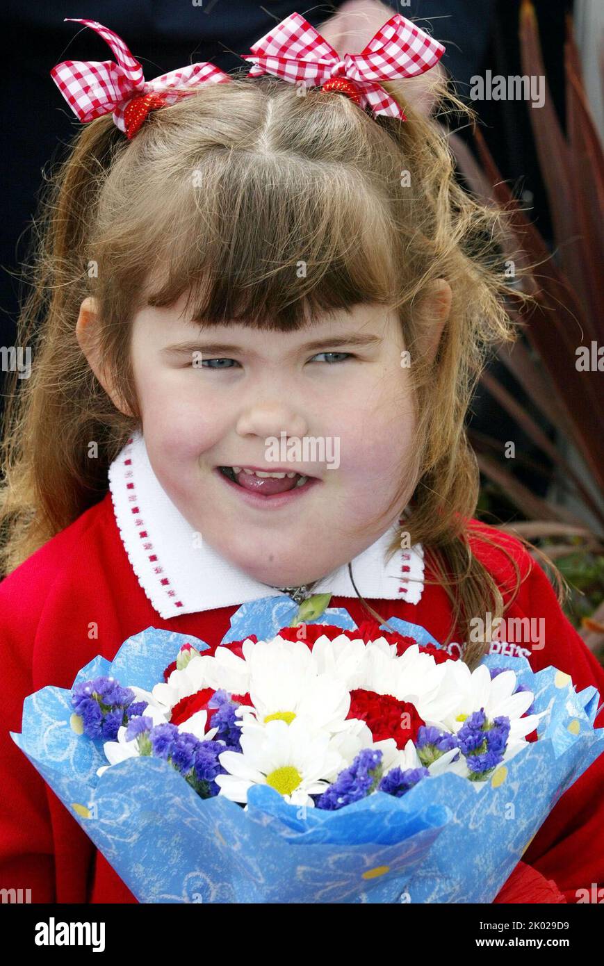 Photo du dossier datée du 7/5/2002 de Katie Meehan, avant de présenter des fleurs à la reine Elizabeth II lors de sa visite à l'école primaire St Josephs RC, Jurow, Tyne et Wear. L'influenceur britannique sur les médias sociaux, dont la réunion avec la reine âgée de six ans a fait les gros titres des journaux il y a 20 ans, a déclaré que « une expérience saine et merveilleuse » lui a montré qu'elle « peut faire n'importe quoi ». Date de la photo: Vendredi 9 septembre 2022. Banque D'Images