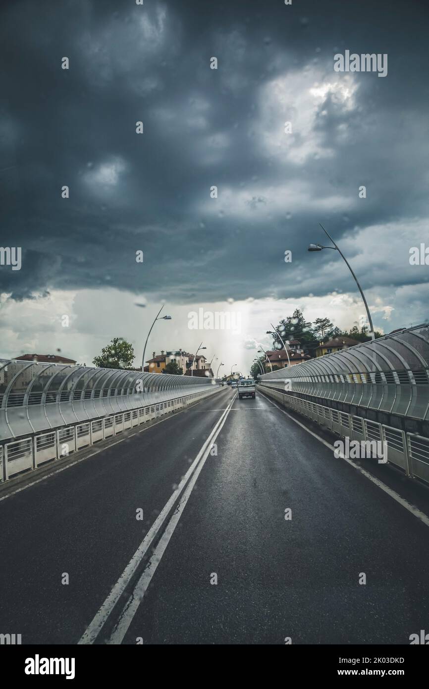 Italie, Vénétie, Belluno. Vue sur la route depuis l'intérieur d'une voiture, avec un ciel spectaculaire et un orage venant en sens inverse Banque D'Images