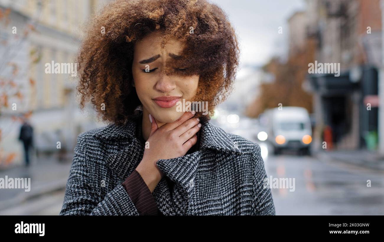 Portrait de femme jeune triste mauriquement africaine fille américaine sensation mal de gorge inconfort toux souffrant de symptômes grippaux de l'asthme du coronavirus Banque D'Images