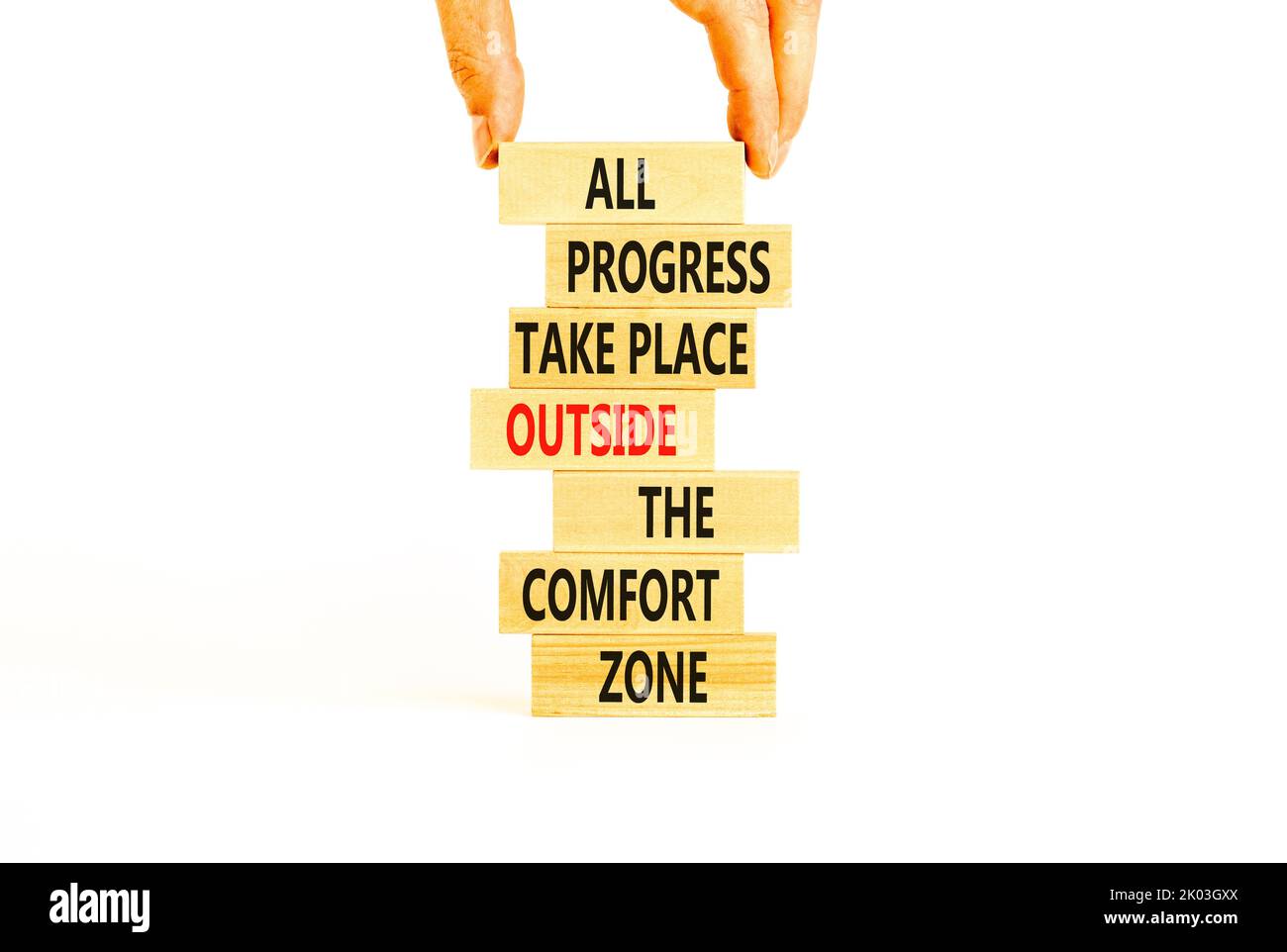 Symbole de progression. Mots de concept tous les progrès ont lieu en dehors de la zone de confort sur des blocs de bois sur un magnifique fond blanc. Main d'homme d'affaires. Unité commerciale Banque D'Images