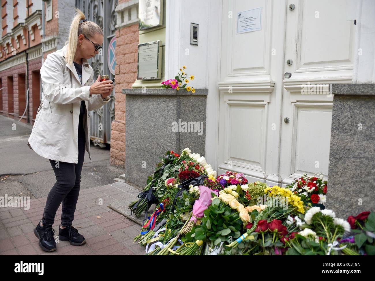 KIEV, UKRAINE - le 9 SEPTEMBRE 2022 - Une femme laisse une lanterne de vigile devant l'ambassade britannique en souvenir de la Reine Elizabeth II, qui a passé awa Banque D'Images