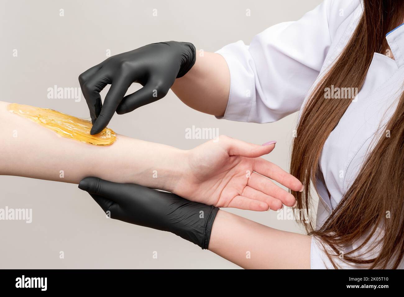 esthéticienne femme épilation au bras au miel Banque D'Images